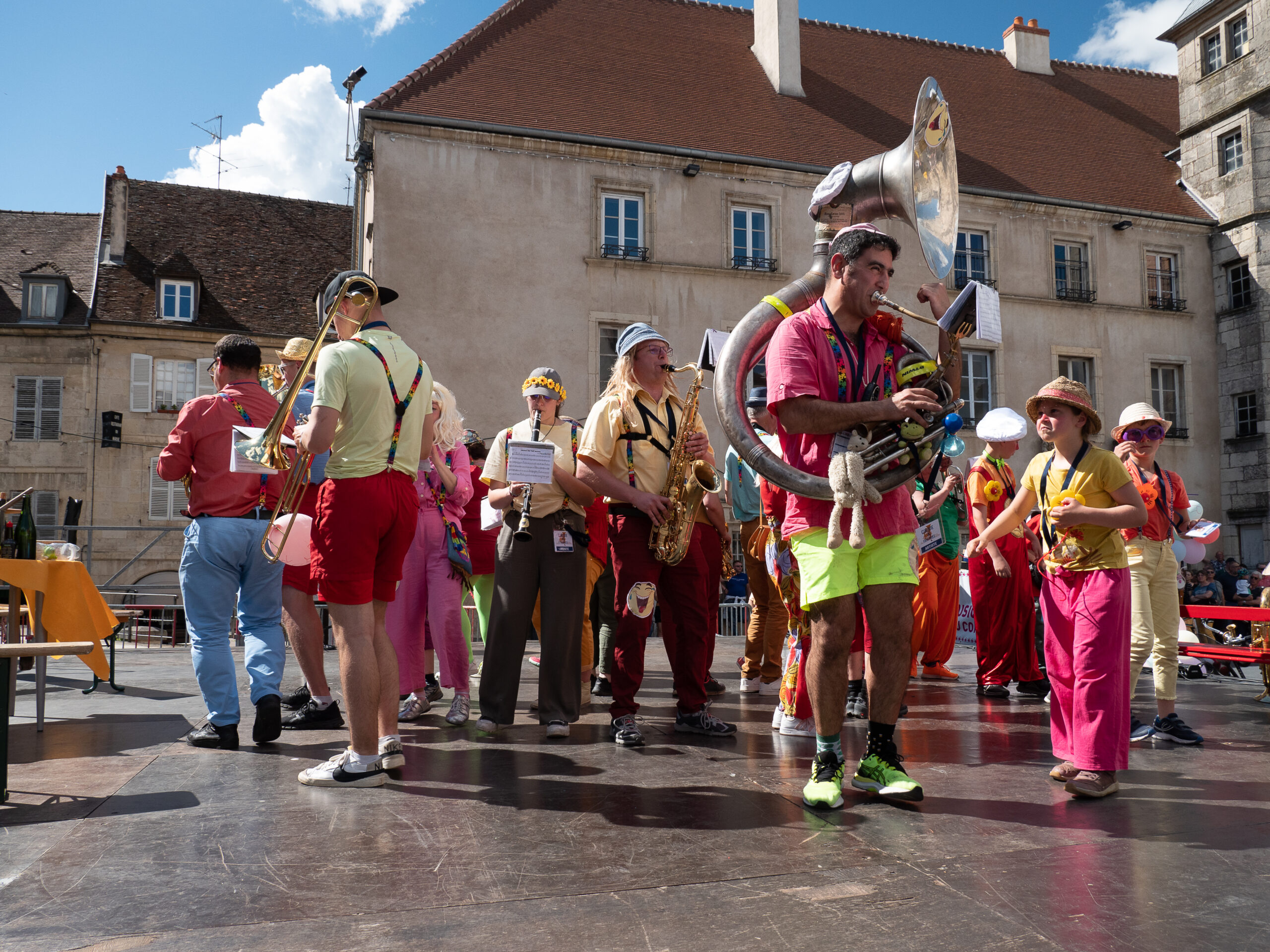 fanfare très colorée, sur une place de Dole. On aperçoit tuba, saxophone, trombone et clarinette parmi la vingtaine de personnes, adultes et enfants