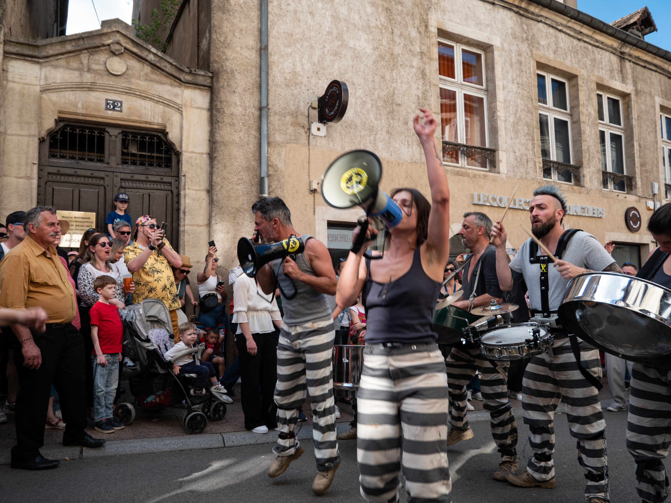 La même troupe, dont on aperçoit à la fois les personnes au mégaphone et les percussionnistes