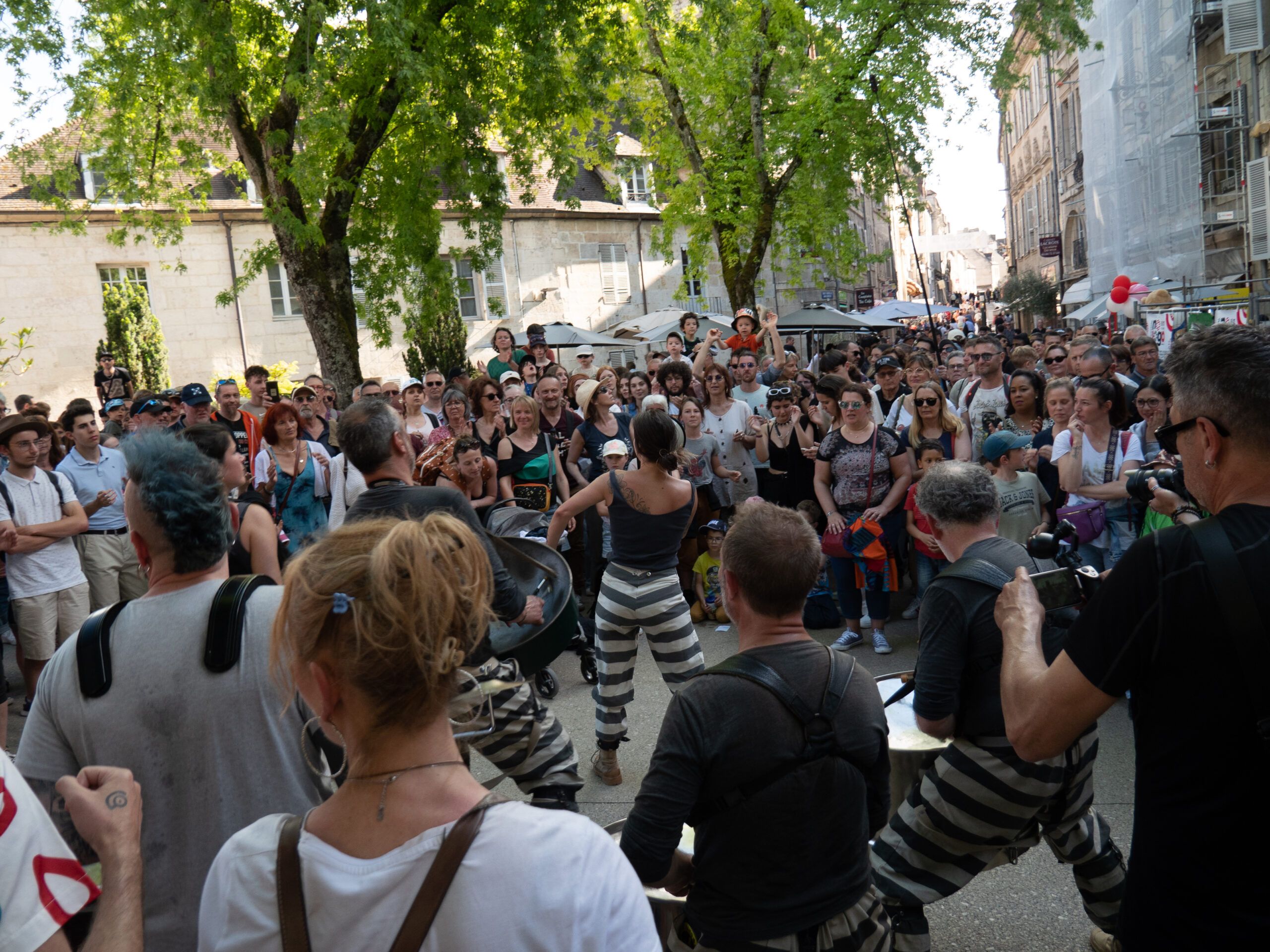 La même troupe, vue de dos, avec la foule très compacte venue assister à la représentation