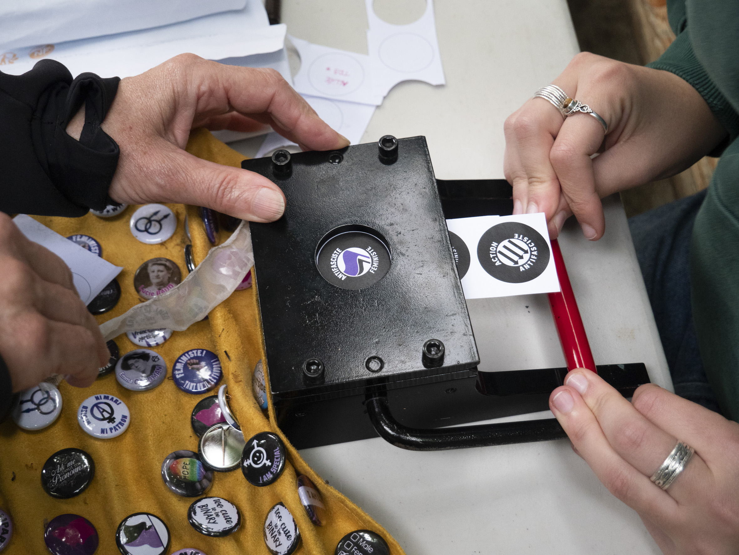 séance de création de badge, vue en gros plan d'une paire de mains sur la badgeuse