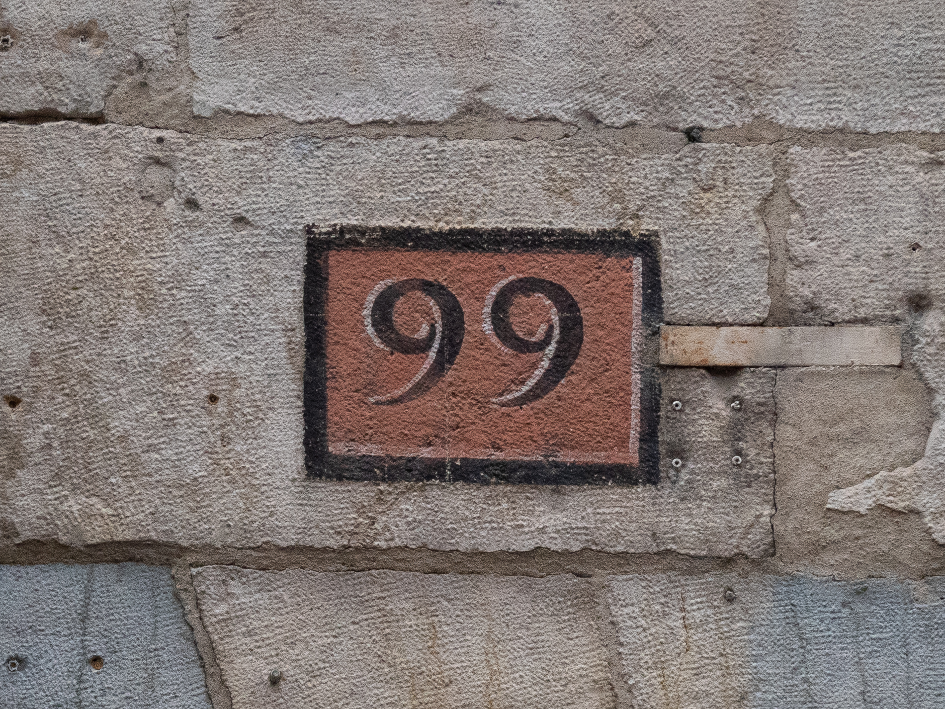 le nombre 99 peint dans une imitation de mosaïque romaine
