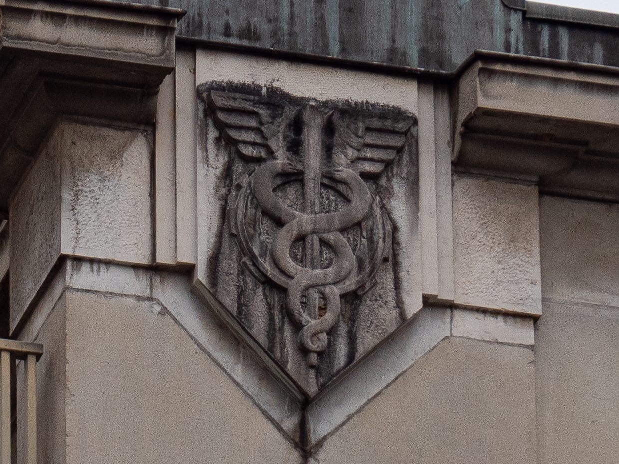 bas relief en pierre représentant un caducée autour duquel s'enroulent deux serpents qui se font face