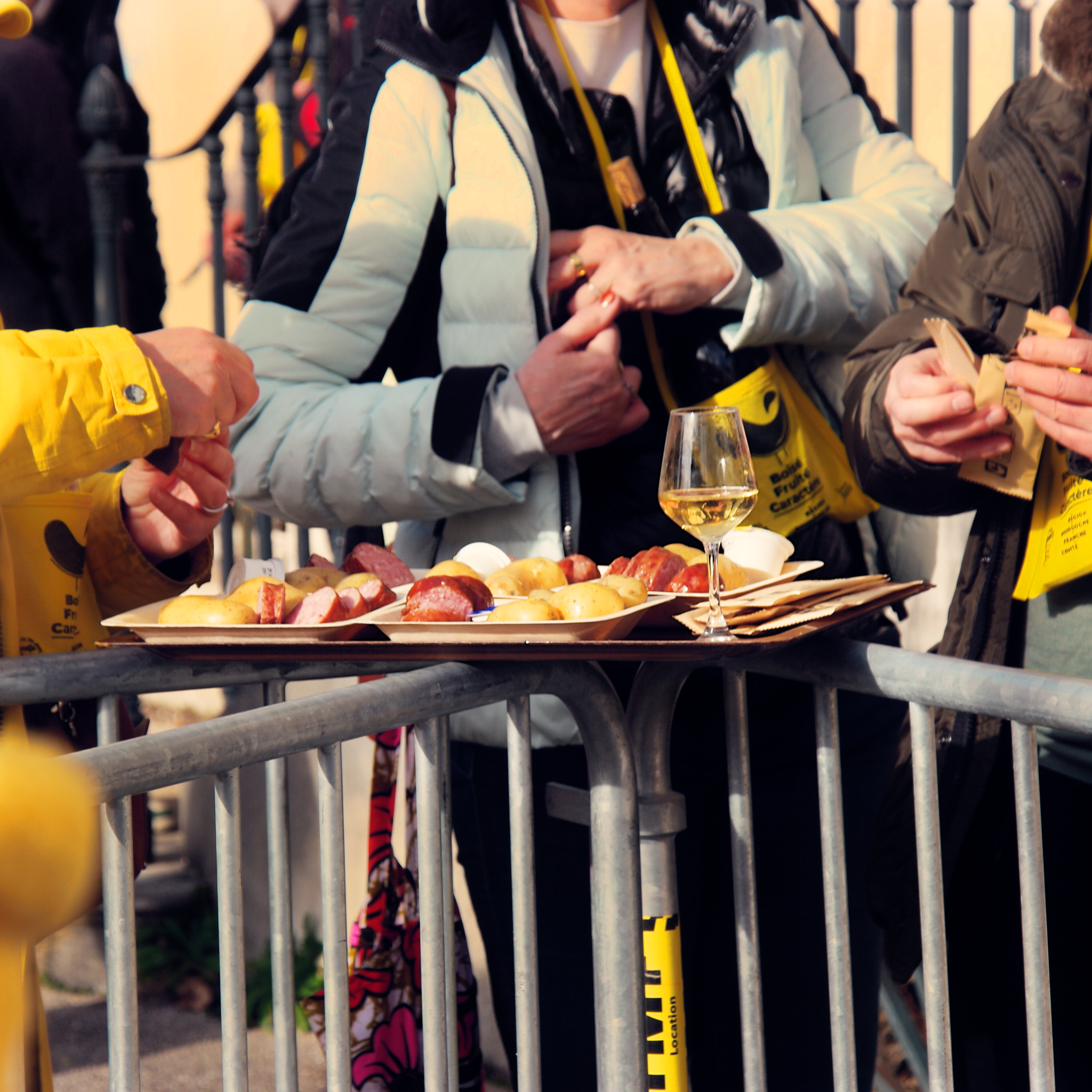 plateaux de patates et saucisse de Morteau en train d'être dégustées sur des barrières de sécurité