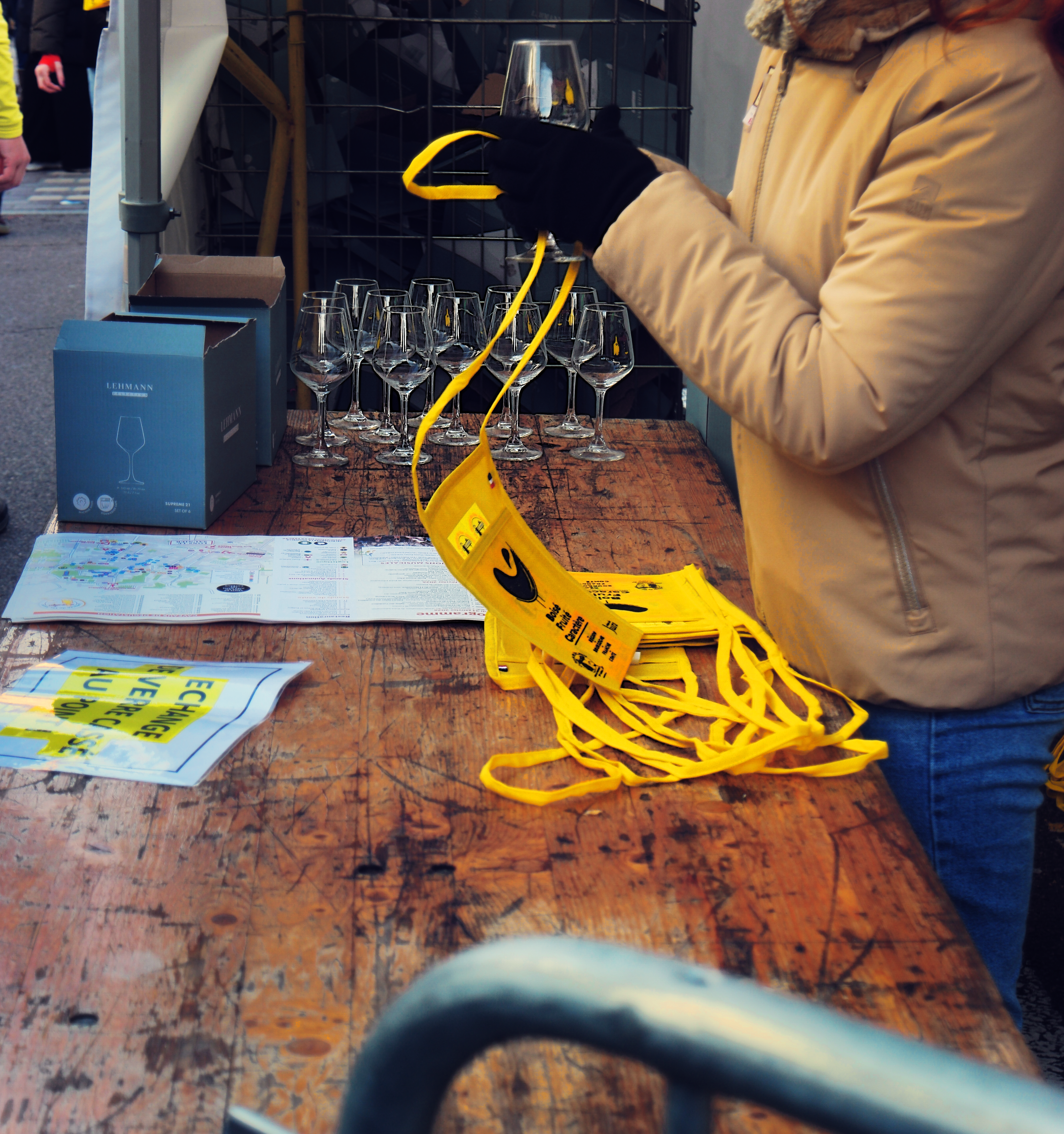 Personne distribuant les verres à vin jaune ainsi que les petites musettes jaunes de l'événement