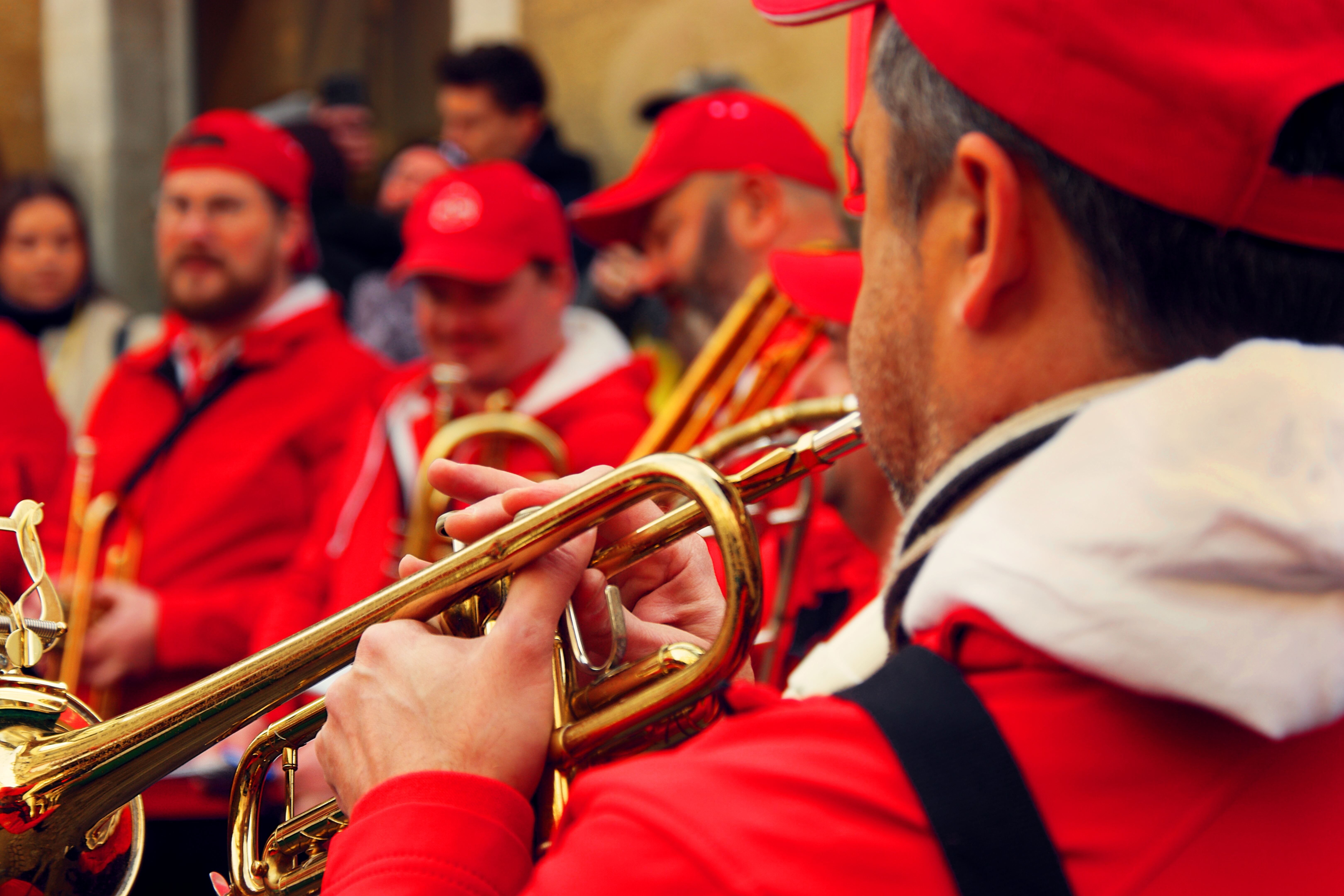 photo de la fanfare en gros plan un trompettiste vu de dos, tous habillés de rouge