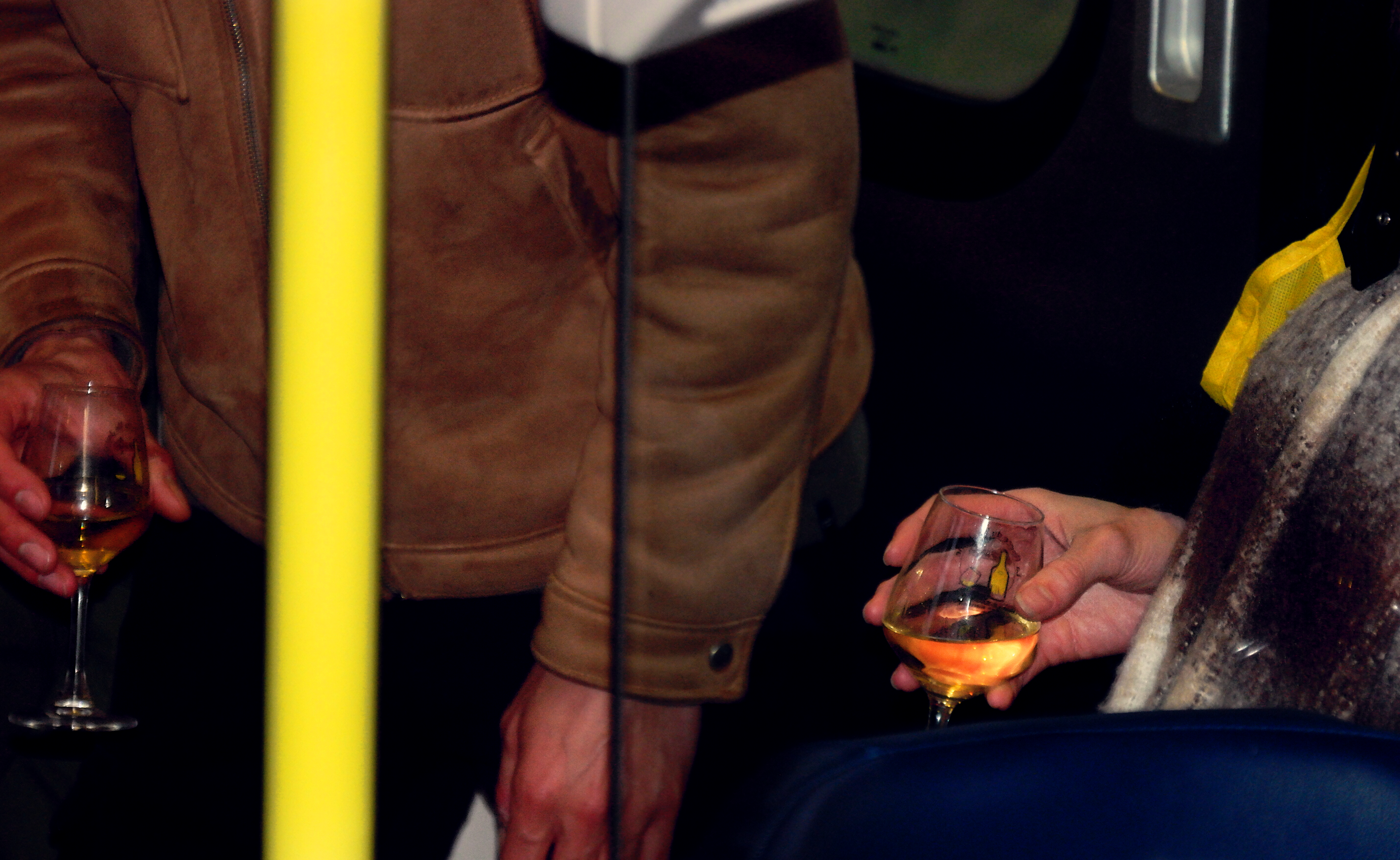 gros plan de deux mains en train de tenir deux verres de vin jaune