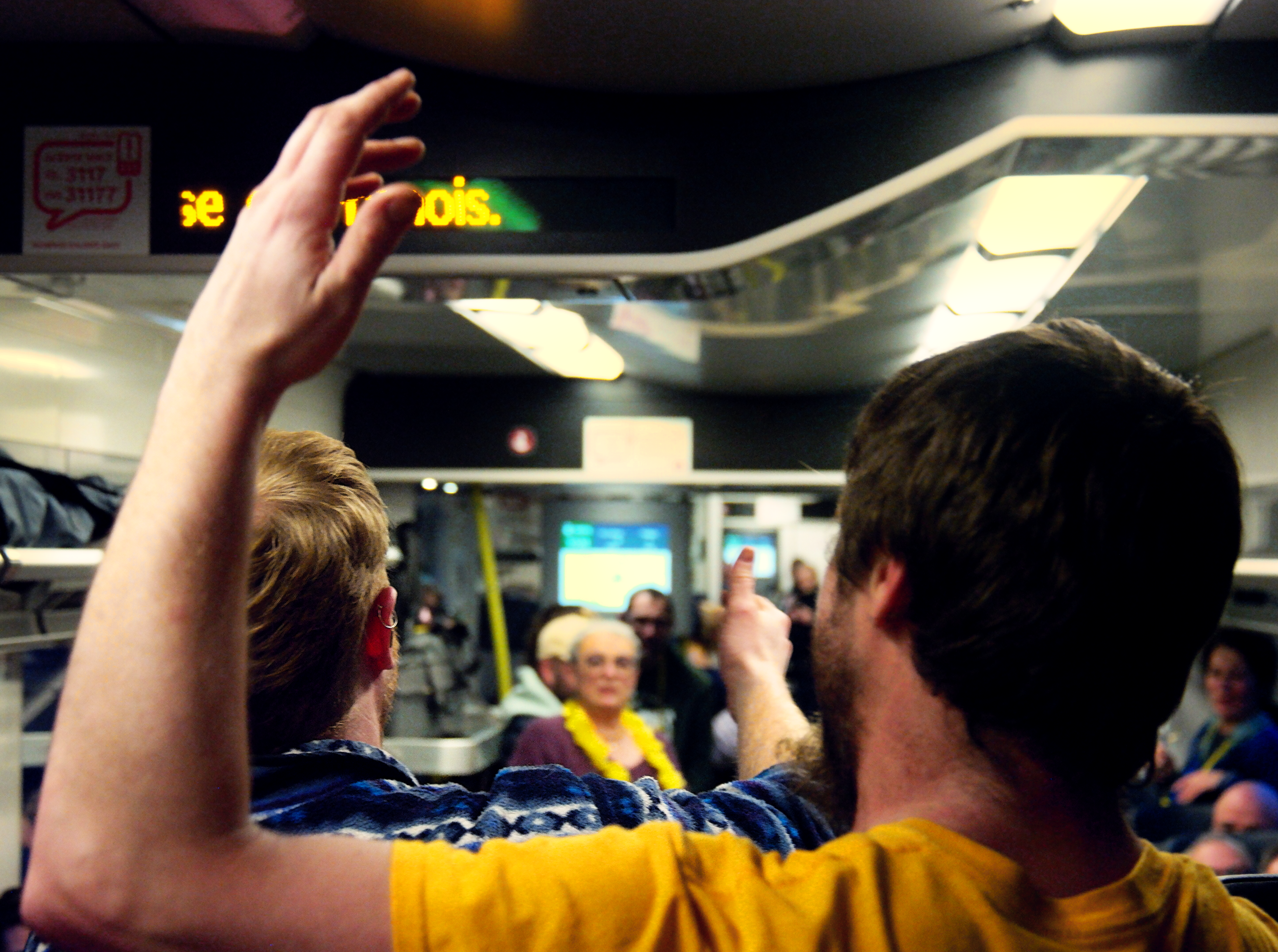 photo de la foule qui chante dans le train du retour, avec les accessoires jaunes de la percée