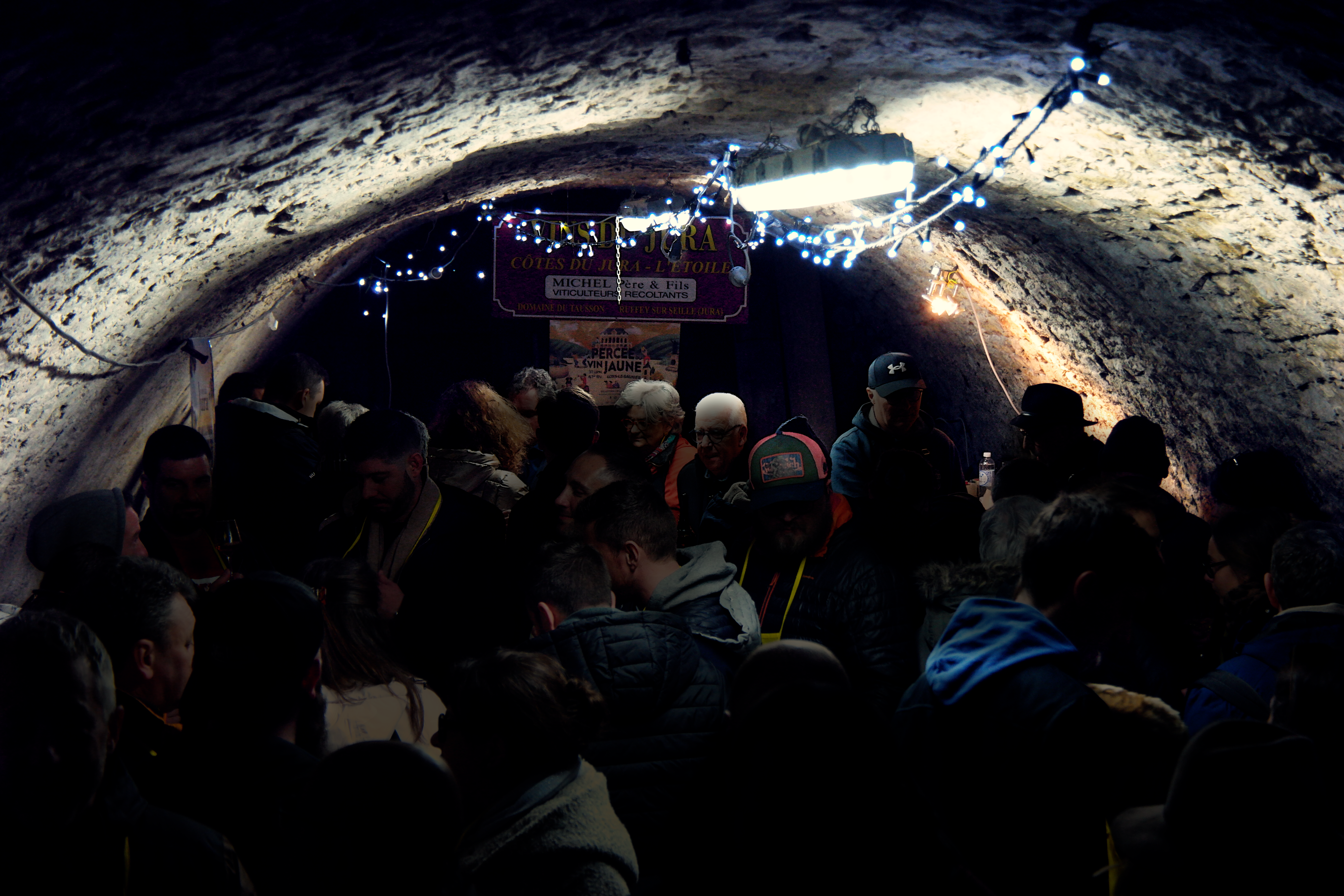 vue de l'intérieur d'une cave à vin, voûtée, noire de monde