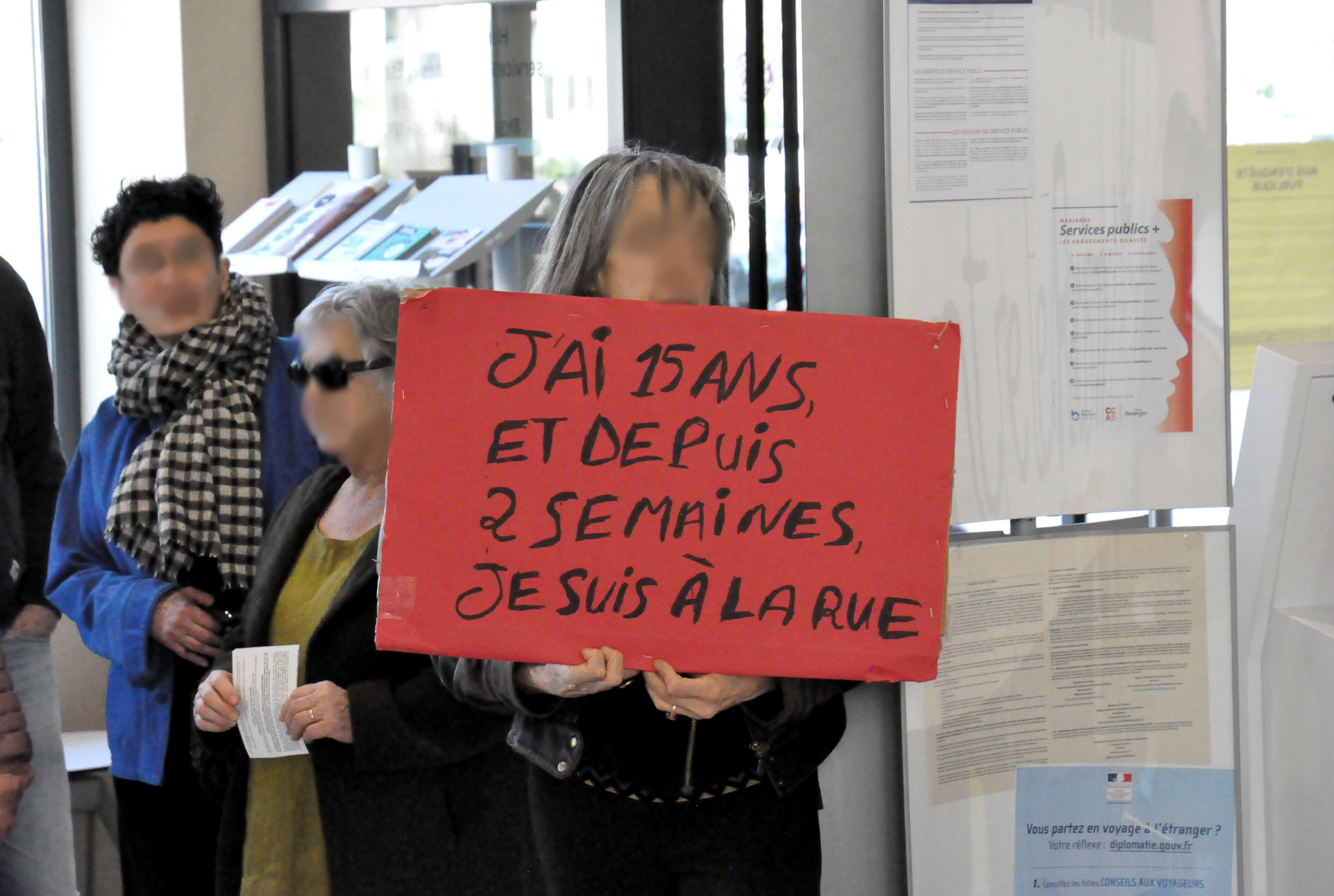 Une personne tient un écriteau "j'ai 15 ans et depuis deux semaines, je suis à la rue".
