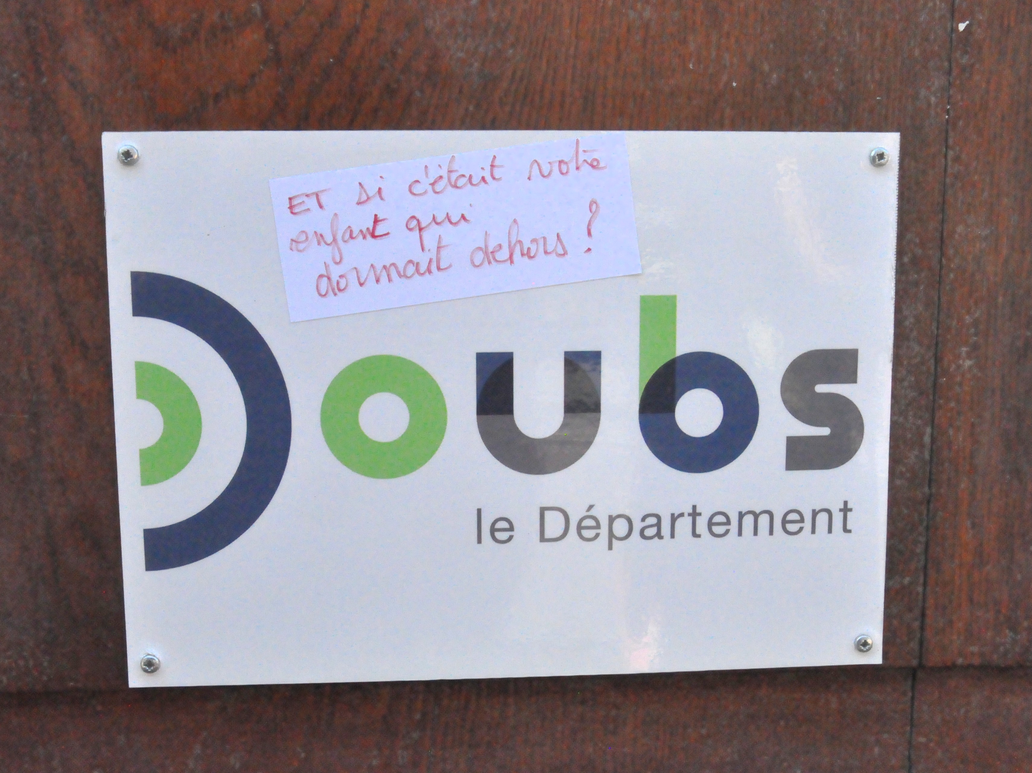 Un sticker sur la plaque du département du Doubs, qui dit : "et si c'était votre enfant qui dormait dehors ?"