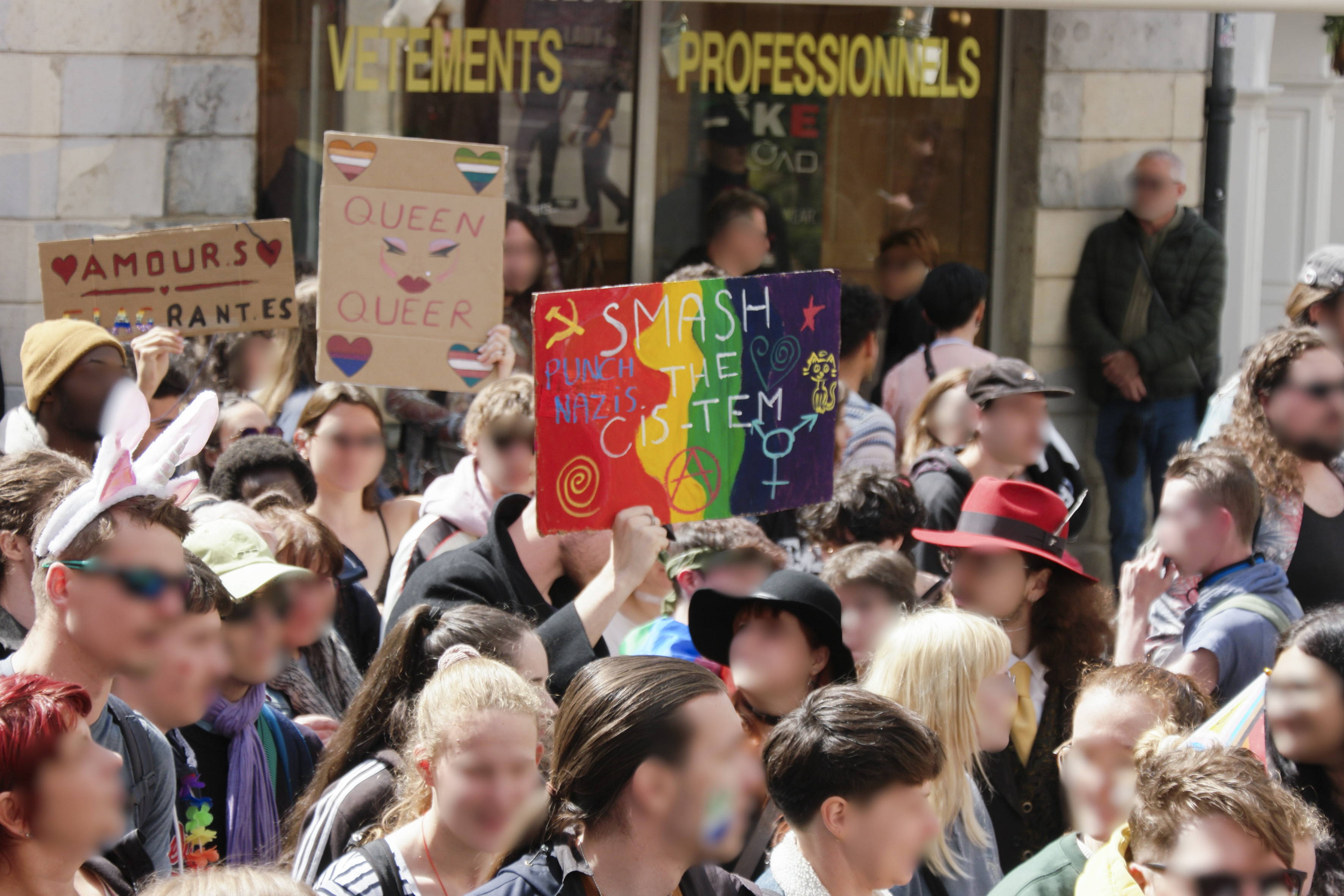 Une pancarte smash the cis-tem, punch nazis, une autre queen queer avec des coeurs aux différentes couleurs de drapeaux LGBT