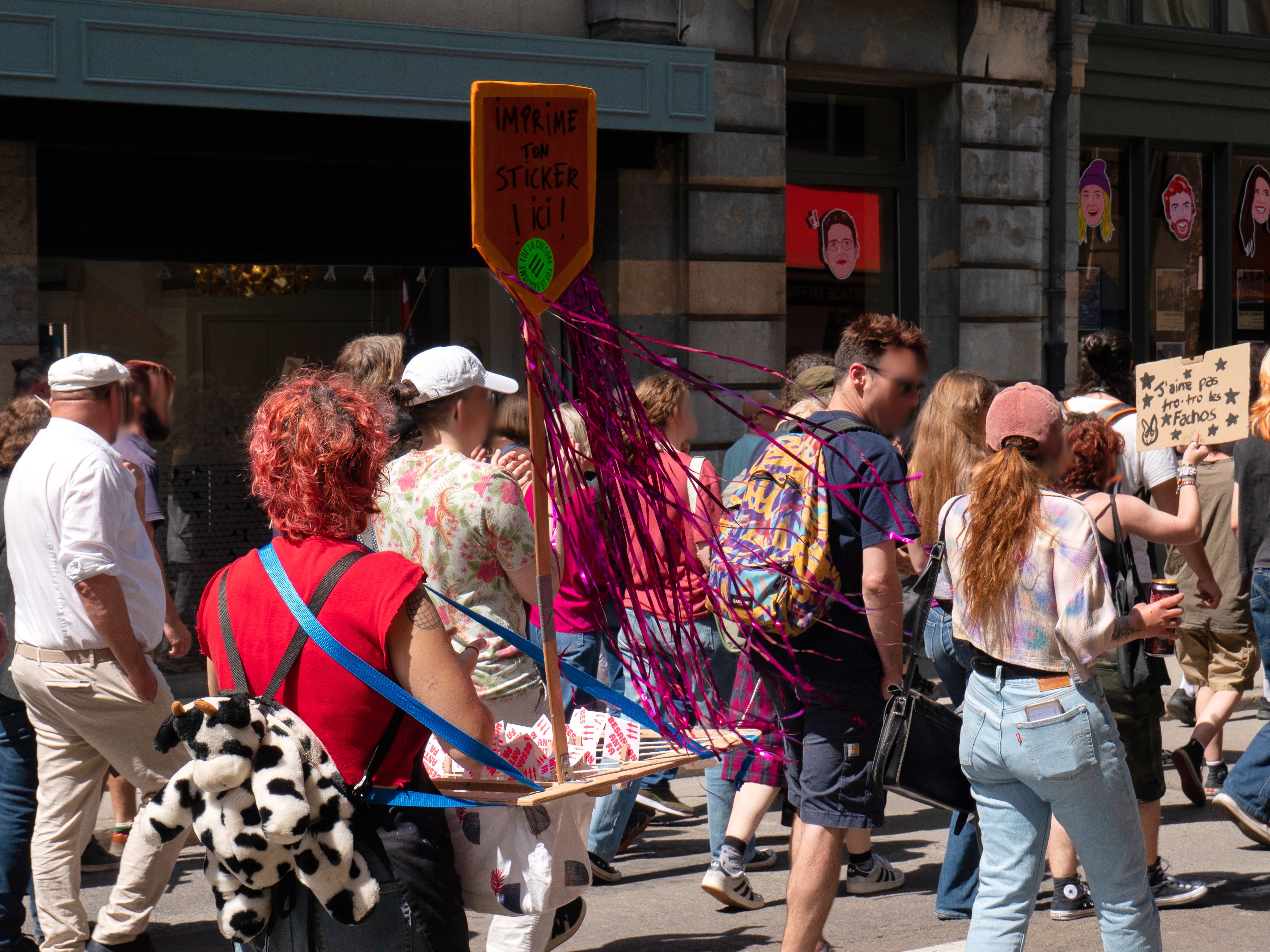 Le stand itinérant d'impression de stickers pendant le défilé, à côté d'une pancarte "j'aime pas tro tro les fachos"