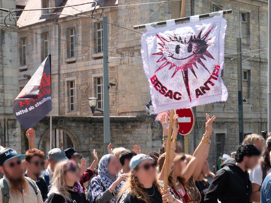 Gros plan sur le drapeau du Baf, un coeur souriant hérissé d'épines. À Côté, un drapeau Solidaires étudiant·es
