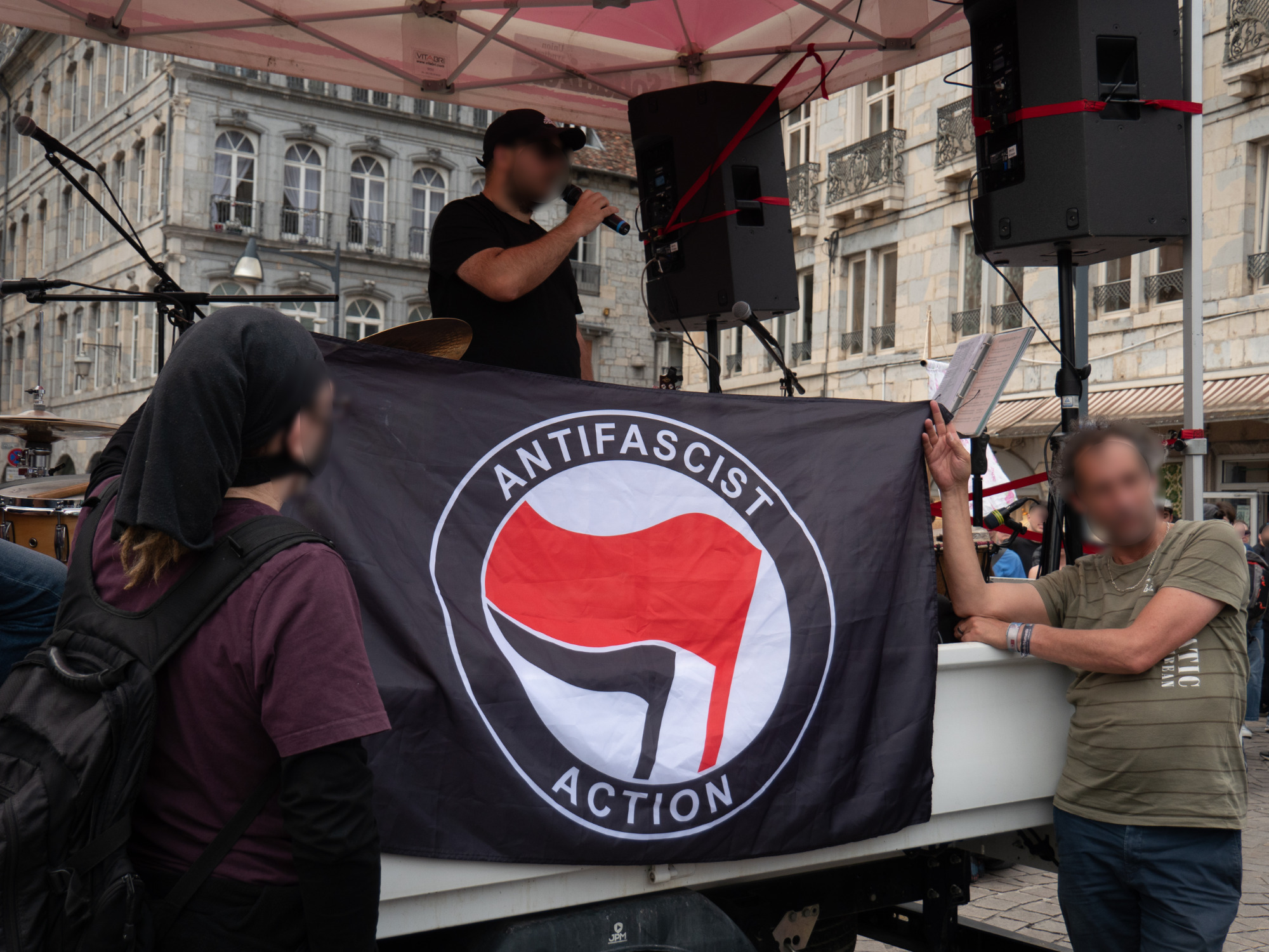 Prise de parole au camion de la sono, avec l'immense drapeau antifascist action déployé à l'avant