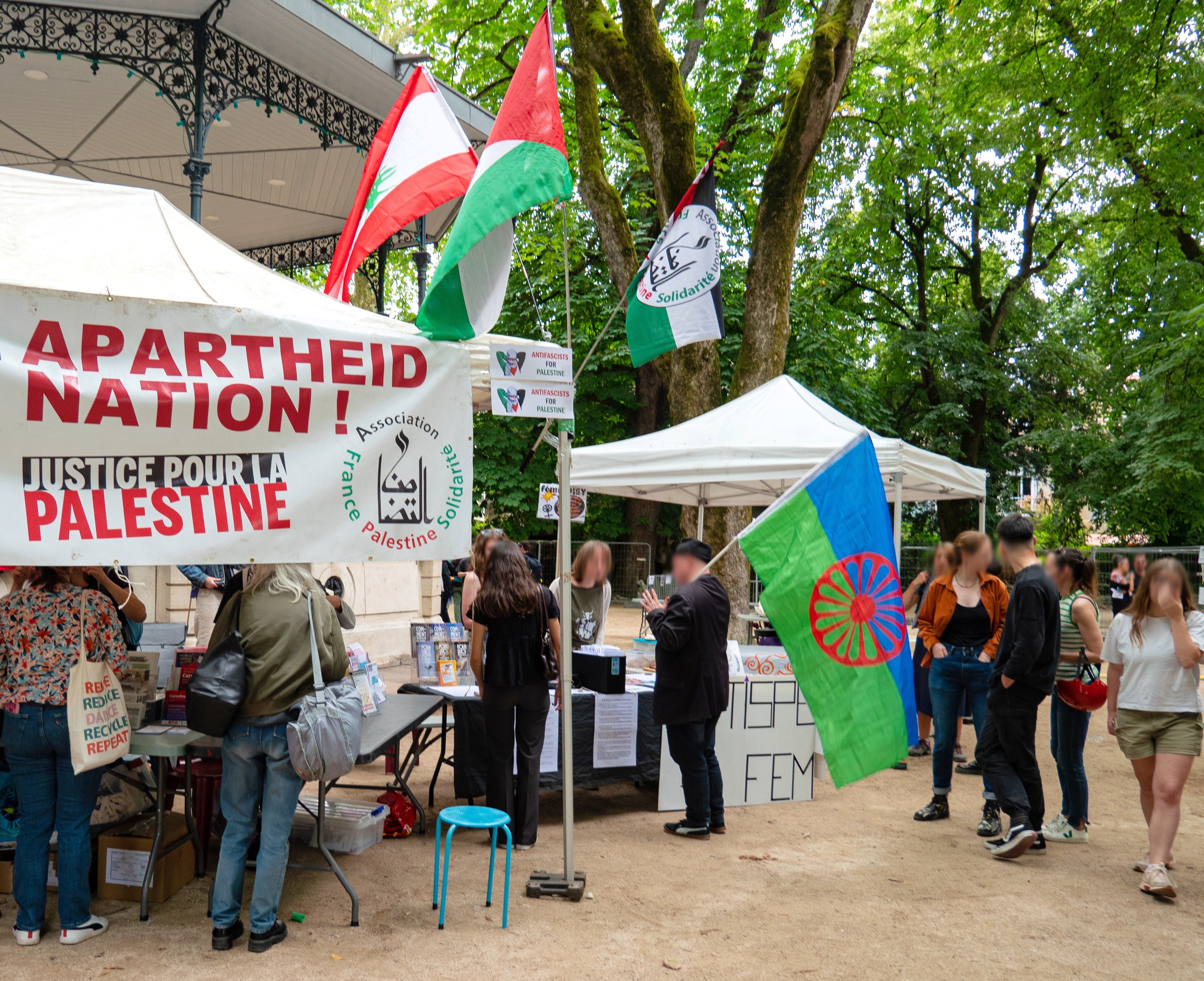 Aperçu du stand de solidarité pour la Palestine, avec à côté un drapeau de la fierté gitane, place Granvelle