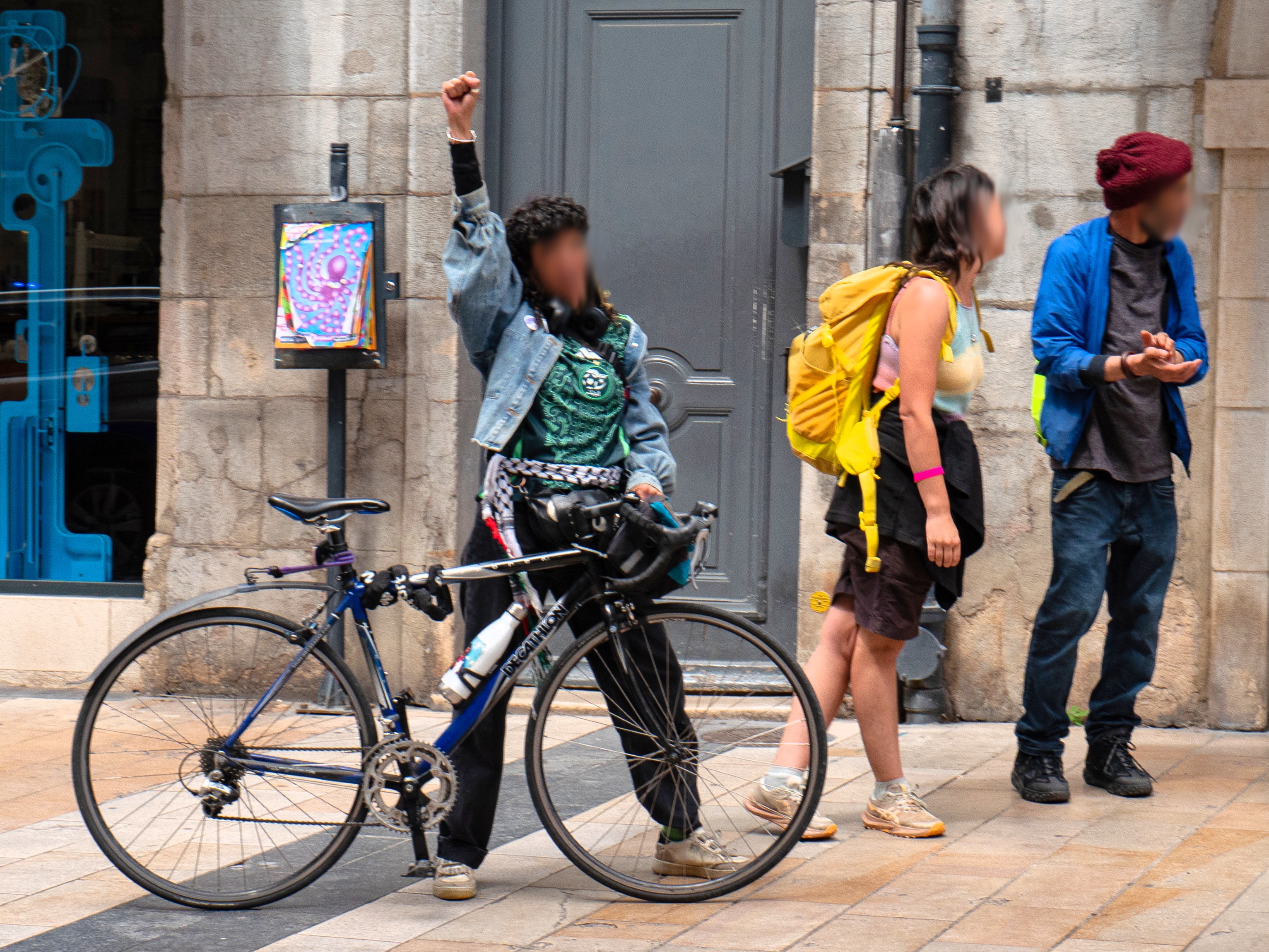 Une femme à côté de son vélo lève le poing au passage du cortège