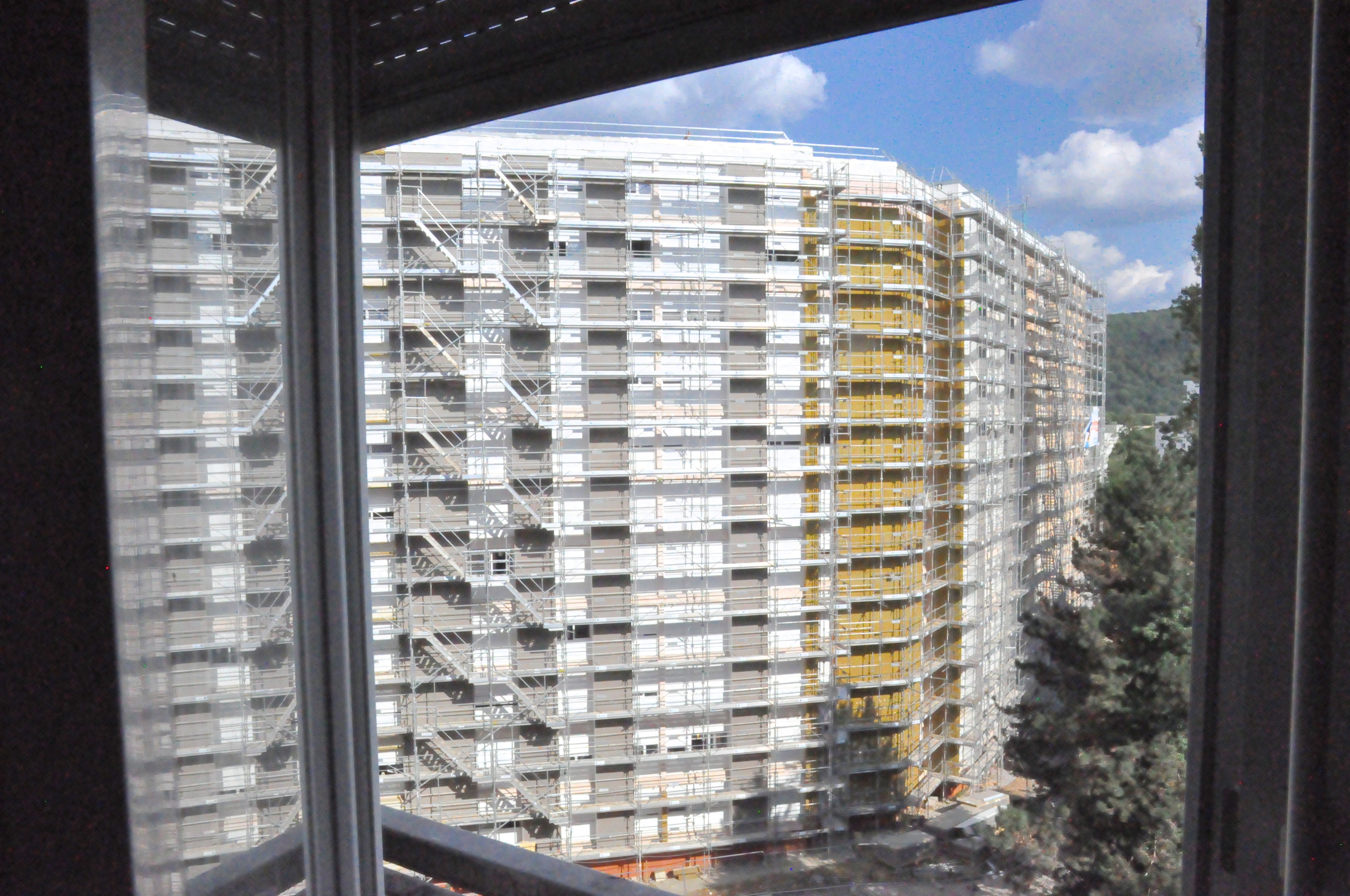 vue de l'immeuble d'en face, couvert d'échafaudages, depuis une fenêtre