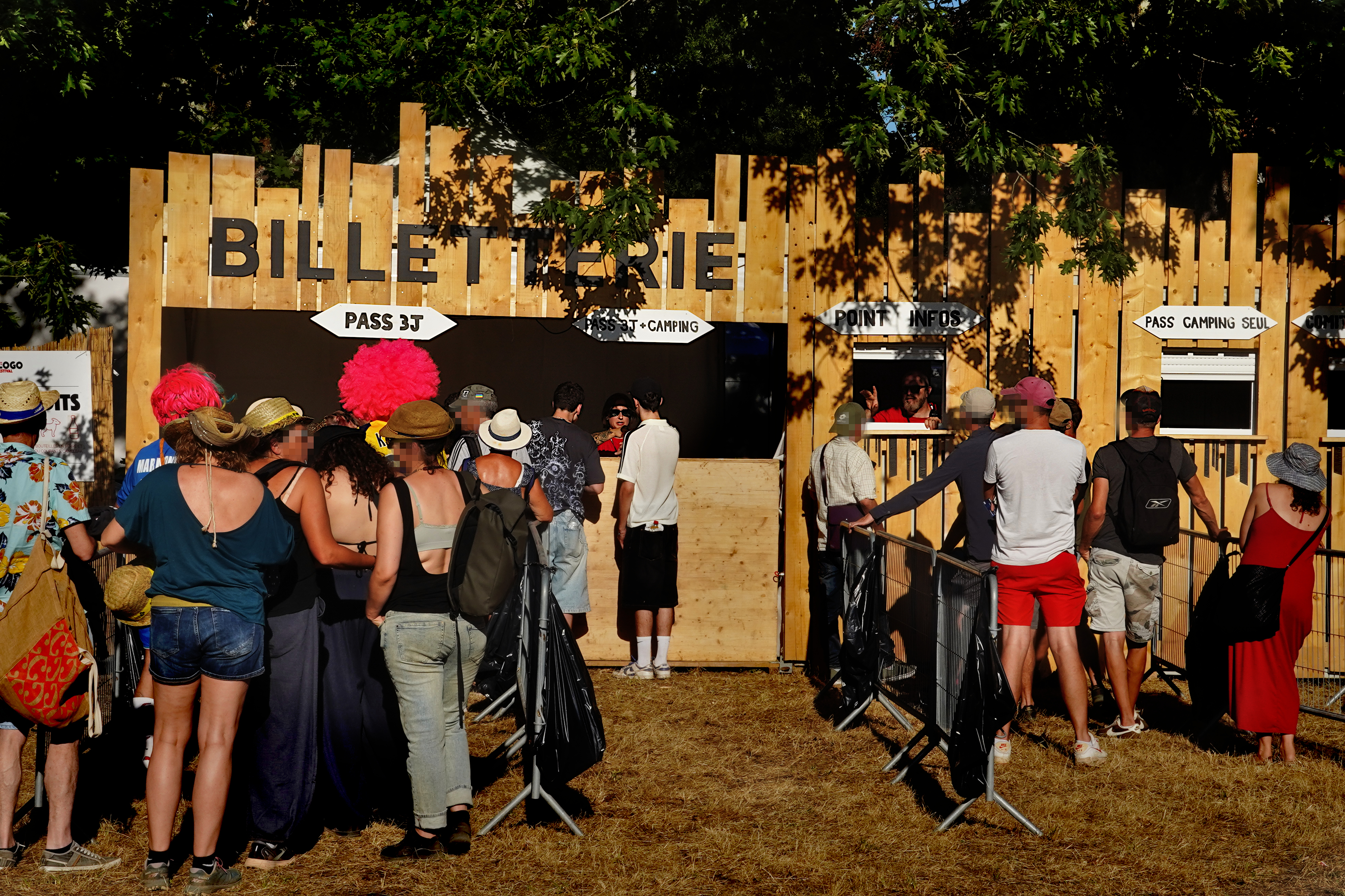 file d'attente devant les divers stands de la billetterie, au soleil