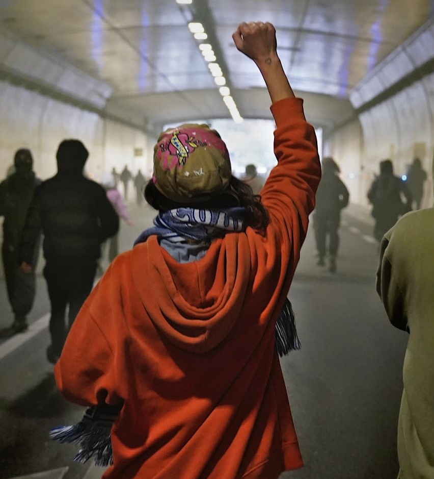 Manifestante avançant le poing levé sous le tunnel sous la citadelle